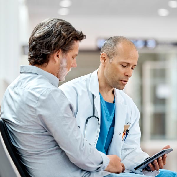 doctor talking to middle aged male patient